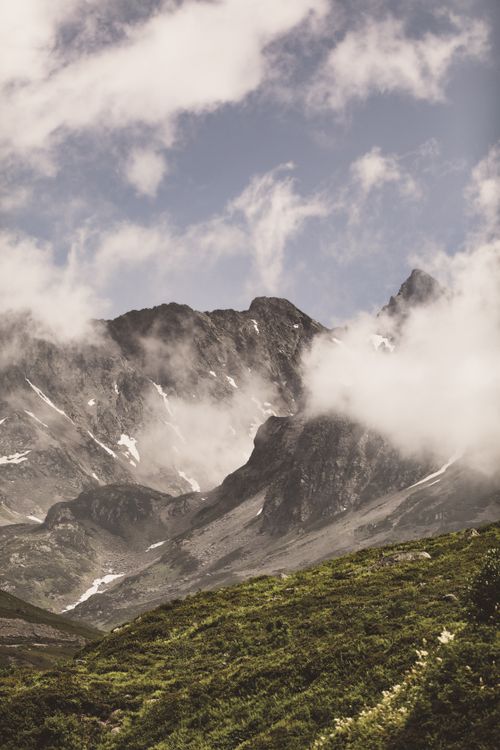 Free Breathtaking view of a misty mountain range with lush greenery in the foreground, perfect for travel inspiration. Stock Photo