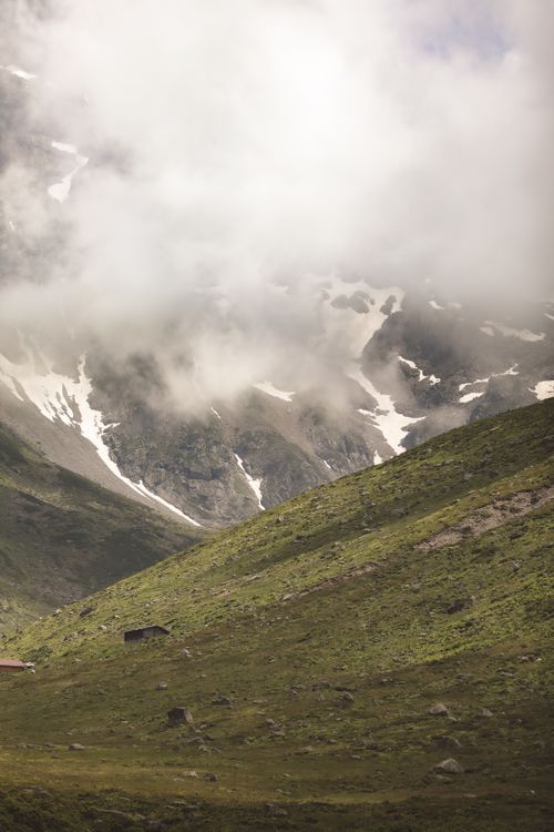 Free A breathtaking view of lush green mountains shrouded in misty clouds, capturing nature's grandeur. Stock Photo