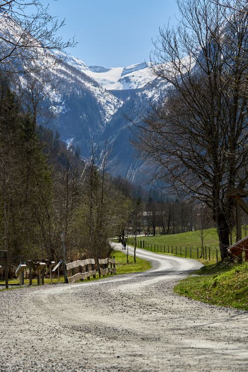 Free Picturesque Salzburg landscape with winding path and snow-capped mountains under a clear sky. Stock Photo
