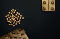 黑色背景上金色药丸与泡罩包装的艺术组合