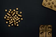 这张概念图以黑色为背景，金色药丸与水泡象征着现代医学