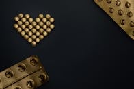 在黑色背景下，将金丸创造性地排列成心形，并预留文字空间