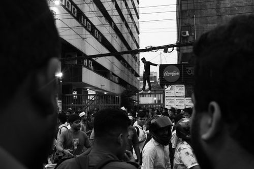 Free A bustling street scene with a man climbing a pole as a crowd gathers, captured in black and white. Stock Photo
