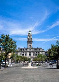 View of the iconic Porto City Hall on Avenida dos Aliados with blue sky and vibrant atmosphere.