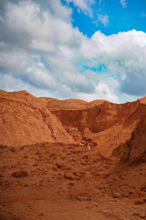Free Explore the striking contrast of red clay and blue sky in this scenic desert landscape. Stock Photo
