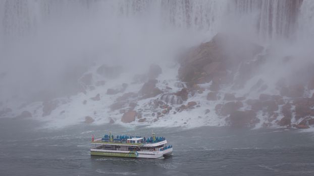A tour boat approaches the misty backdrop of Niagara Falls, capturing the dramatic power of the water.
