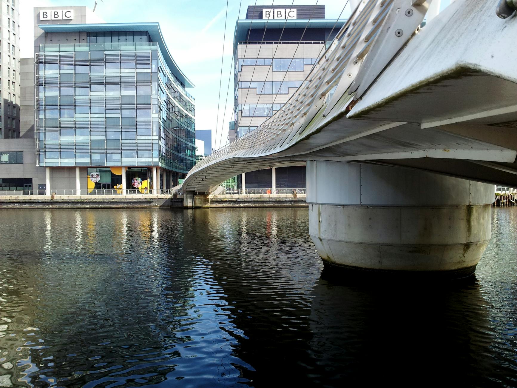 View of modern buildings and bridge at Salford Quays, Manchester's urban waterfront.