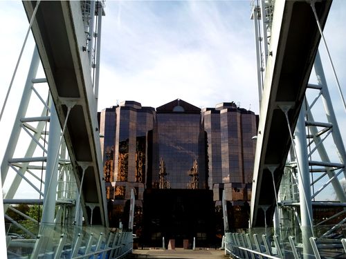 View of reflective skyscraper and steel bridge in Manchester, England.