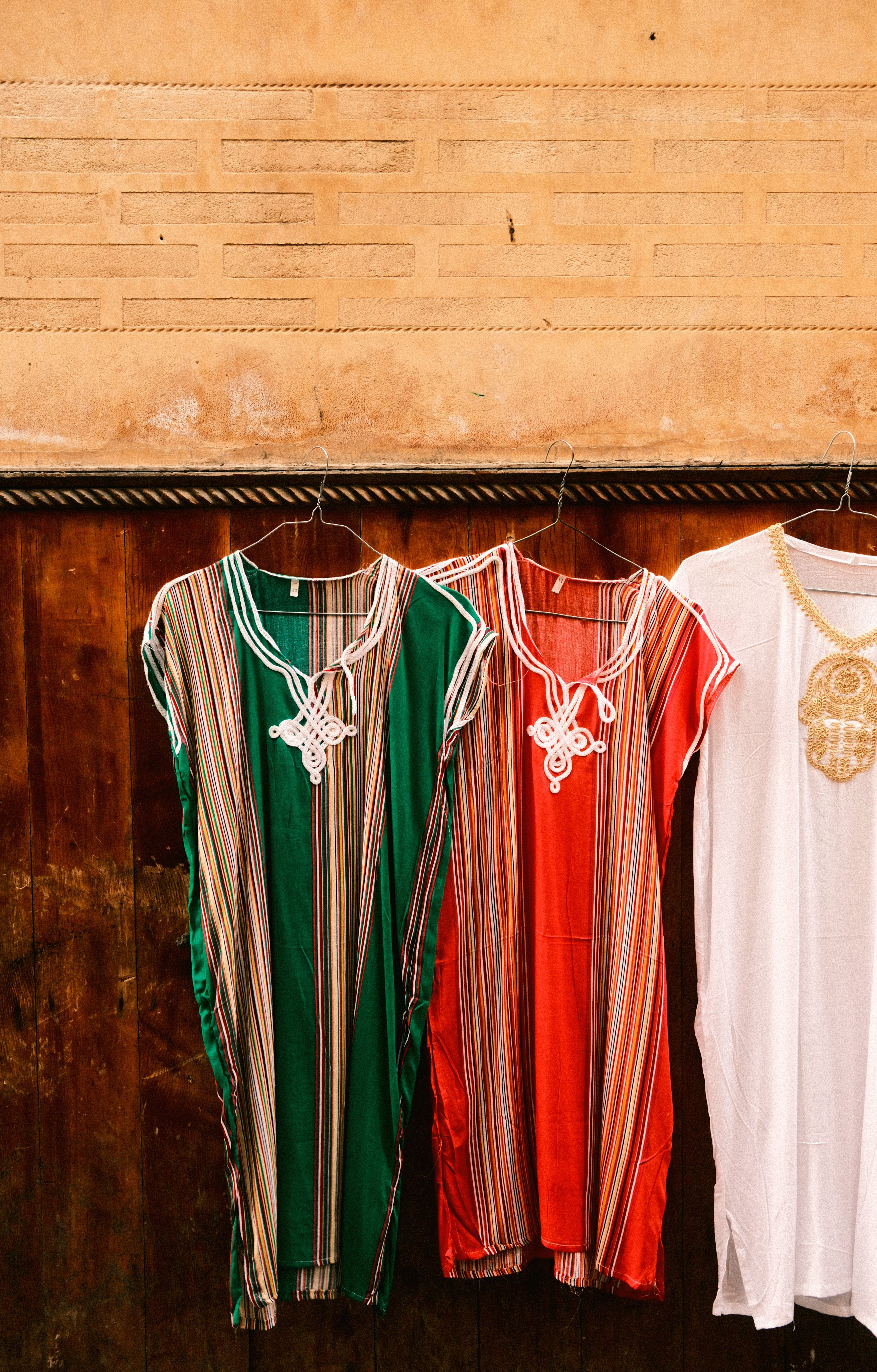 Vibrant traditional Moroccan kaftans displayed in the medina of Fes, showcasing rich cultural fashion.