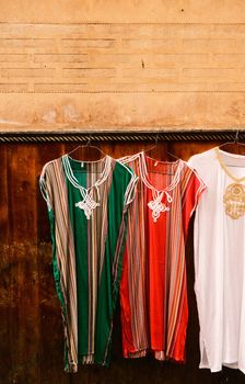 Vibrant traditional Moroccan kaftans displayed in the medina of Fes, showcasing rich cultural fashion.