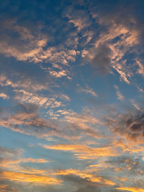 Free A breathtaking view of a vibrant sunset sky with dramatic clouds casting warm hues. Stock Photo