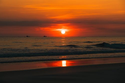 Free Breathtaking sunset with vibrant orange hues reflecting on Quảng Trị beach. Stock Photo