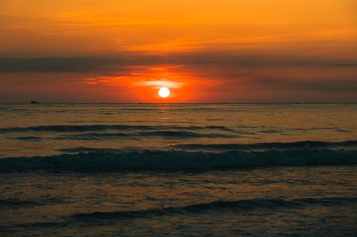 Free A serene view of the sun setting over a calm sea in Quảng Trị, Vietnam. Stock Photo