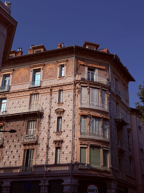 Free A classic European architectural facade with intricate balconies under a clear blue sky. Stock Photo