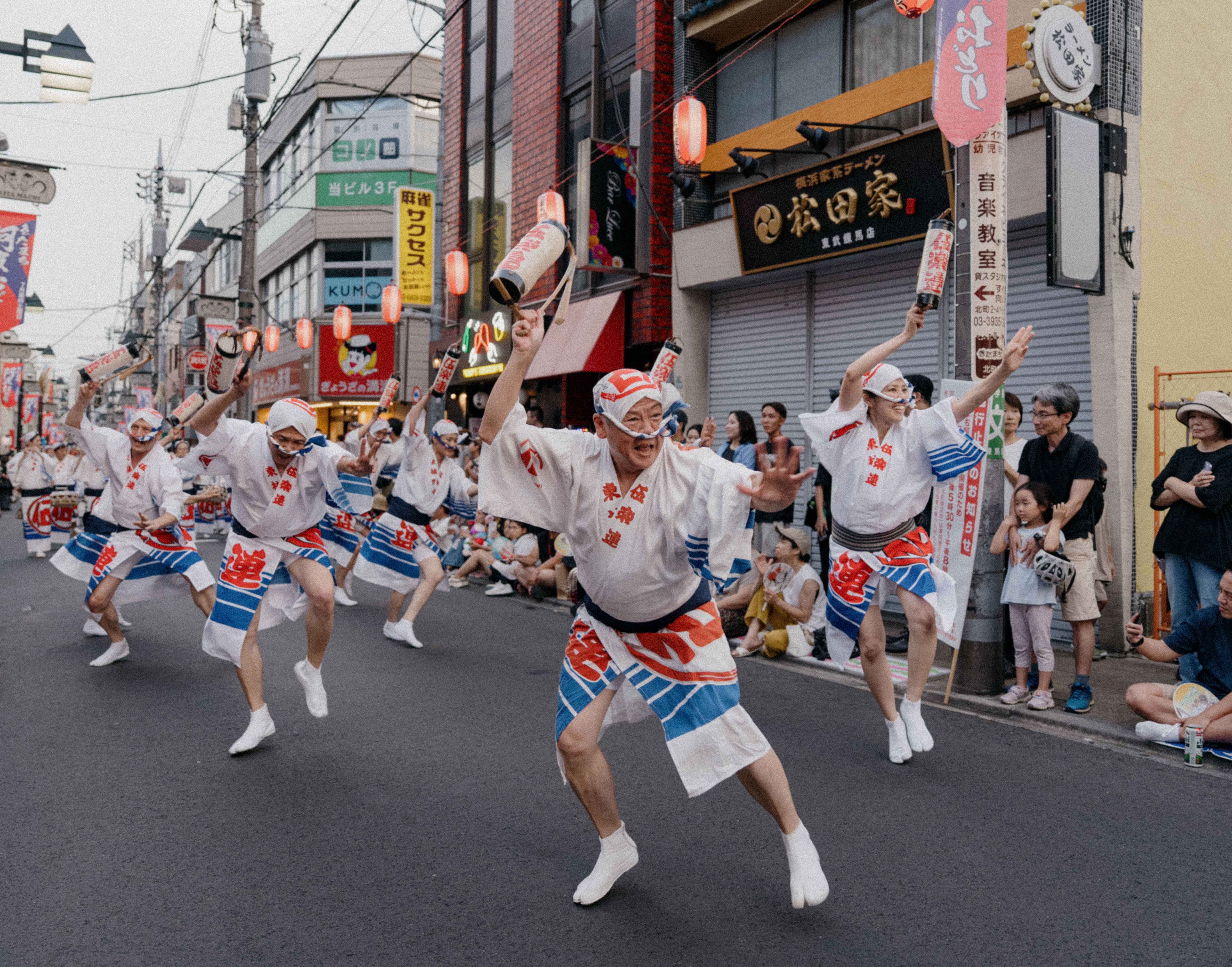 Lively street dance performance at a Japanese festival featuring colorful costumes and lanterns.