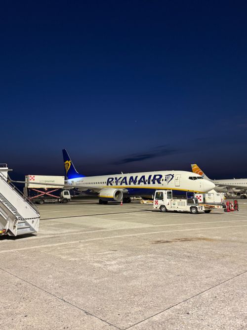 Free A Ryanair aircraft parked at a Lombardia airport during twilight, showcasing travel atmosphere. Stock Photo
