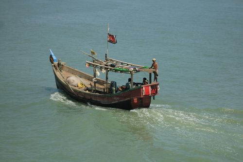 Free A traditional fishing boat navigates the open sea with fishermen on board. Stock Photo
