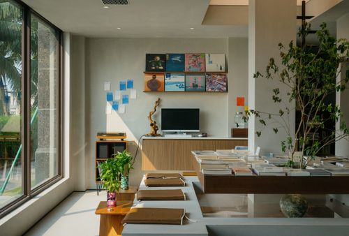 Free Bright modern living room featuring plants, decor, and natural light through large windows. Stock Photo
