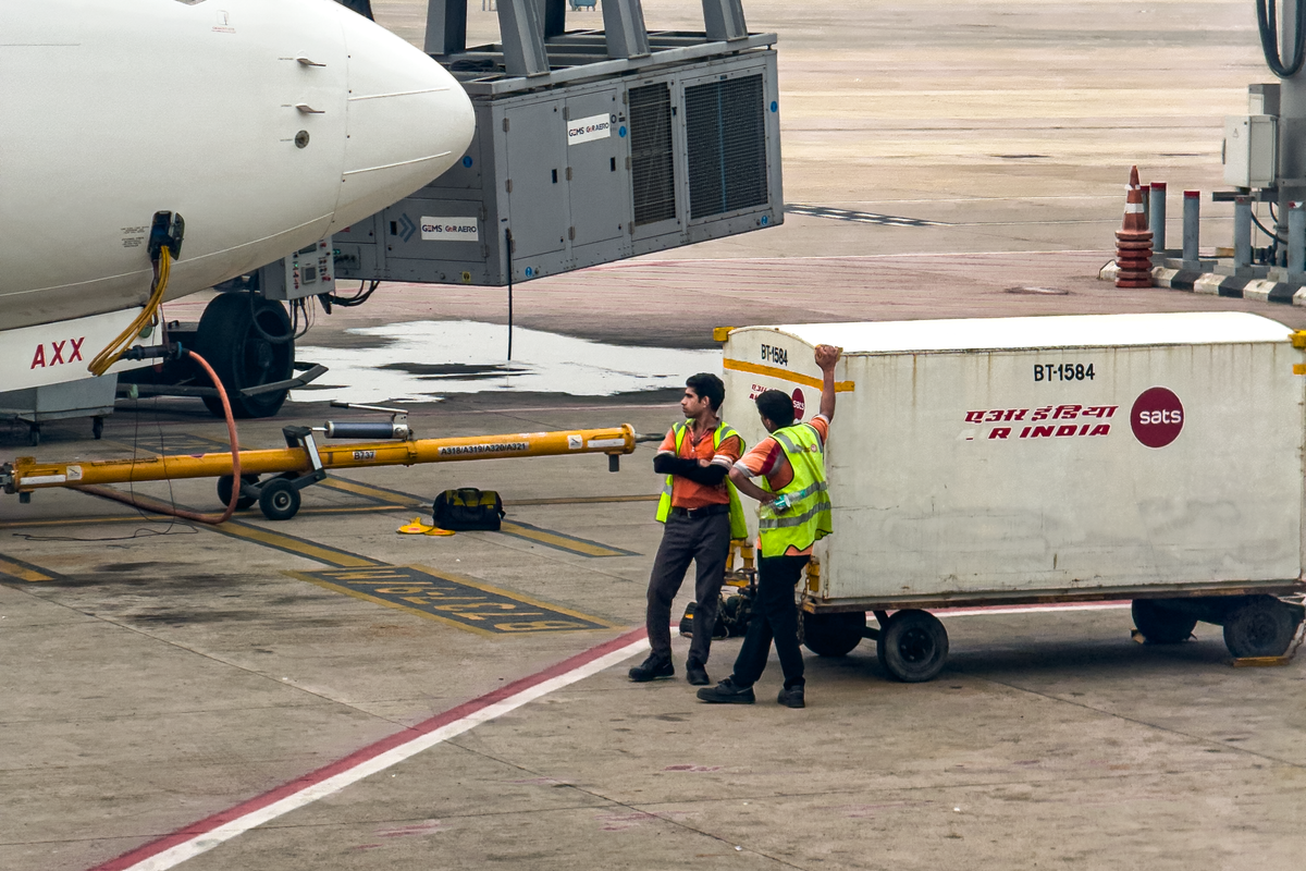 Ground crew loading baggage next to an aircraft