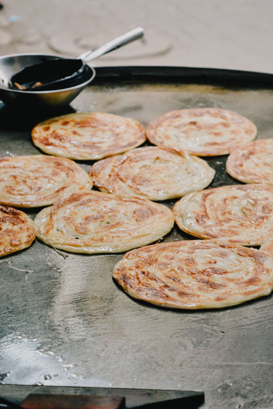 Parathas sizzling on a tawa