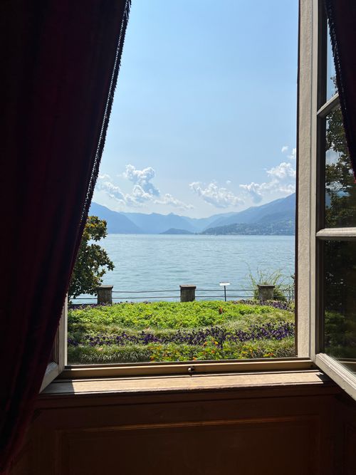 Free Tranquil lake view through an elegant window, showcasing serene waters and distant mountains. Stock Photo