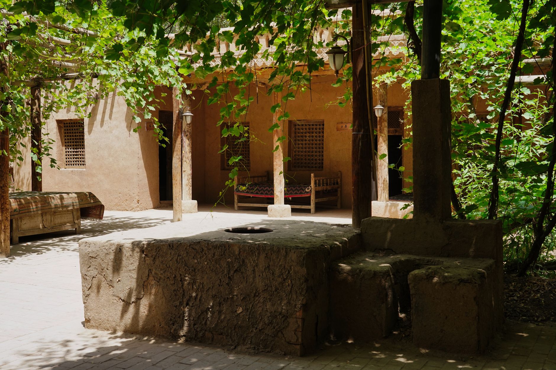 Chinese rural courtyard with covered bird cages, local notices, and officials inspecting an abandoned fighting arena