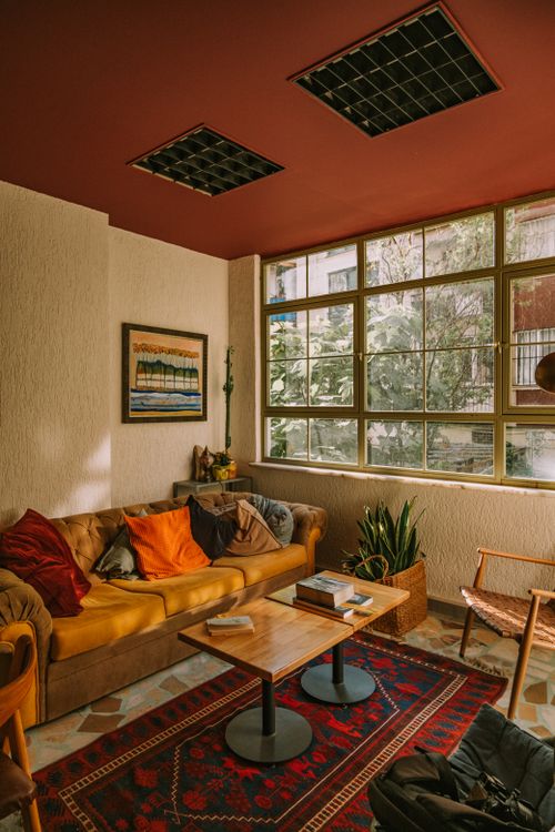 Free Warm and inviting living room with natural light, colorful decor, and comfortable furnishings. Stock Photo