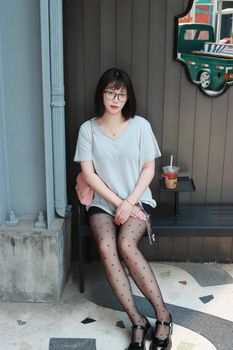 Stylish young woman with polka dot stockings seated in Nanjing enjoying a summer day.