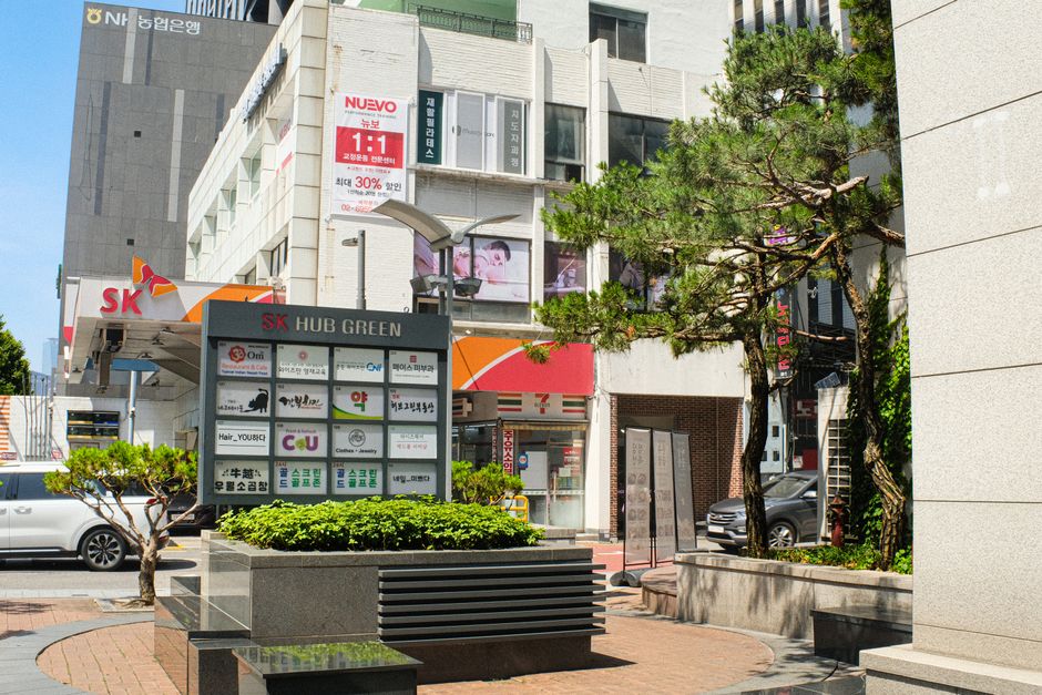 Bright and bustling urban scene in Seoul, showcasing modern architecture and greenery.