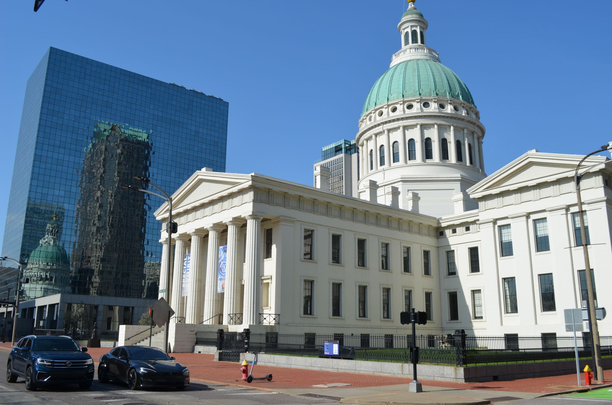 The iconic Old Courthouse with its dome in downtown St. Louis, reflecting in modern glass buildings.