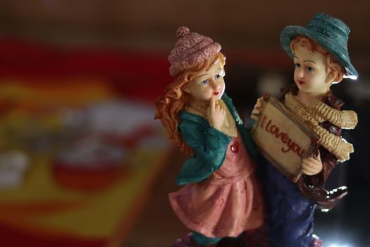 Beautiful handmade porcelain figurine couple with i love you inscription in souvenir shop