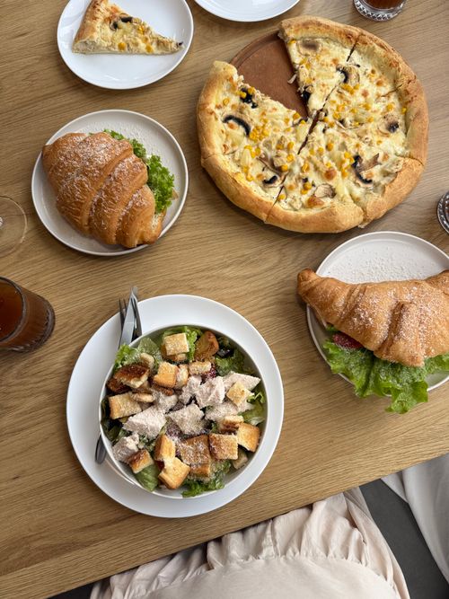 Free Top view of a brunch table with pizza, salad, croissants, and drinks. Stock Photo