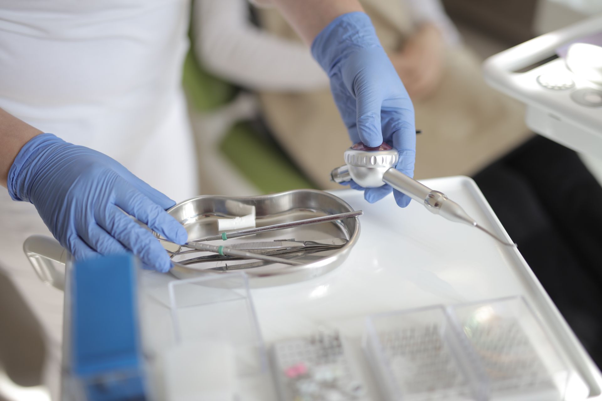 Dental professional handling tools in a sterile clinic environment, ensuring patient hygiene and care.