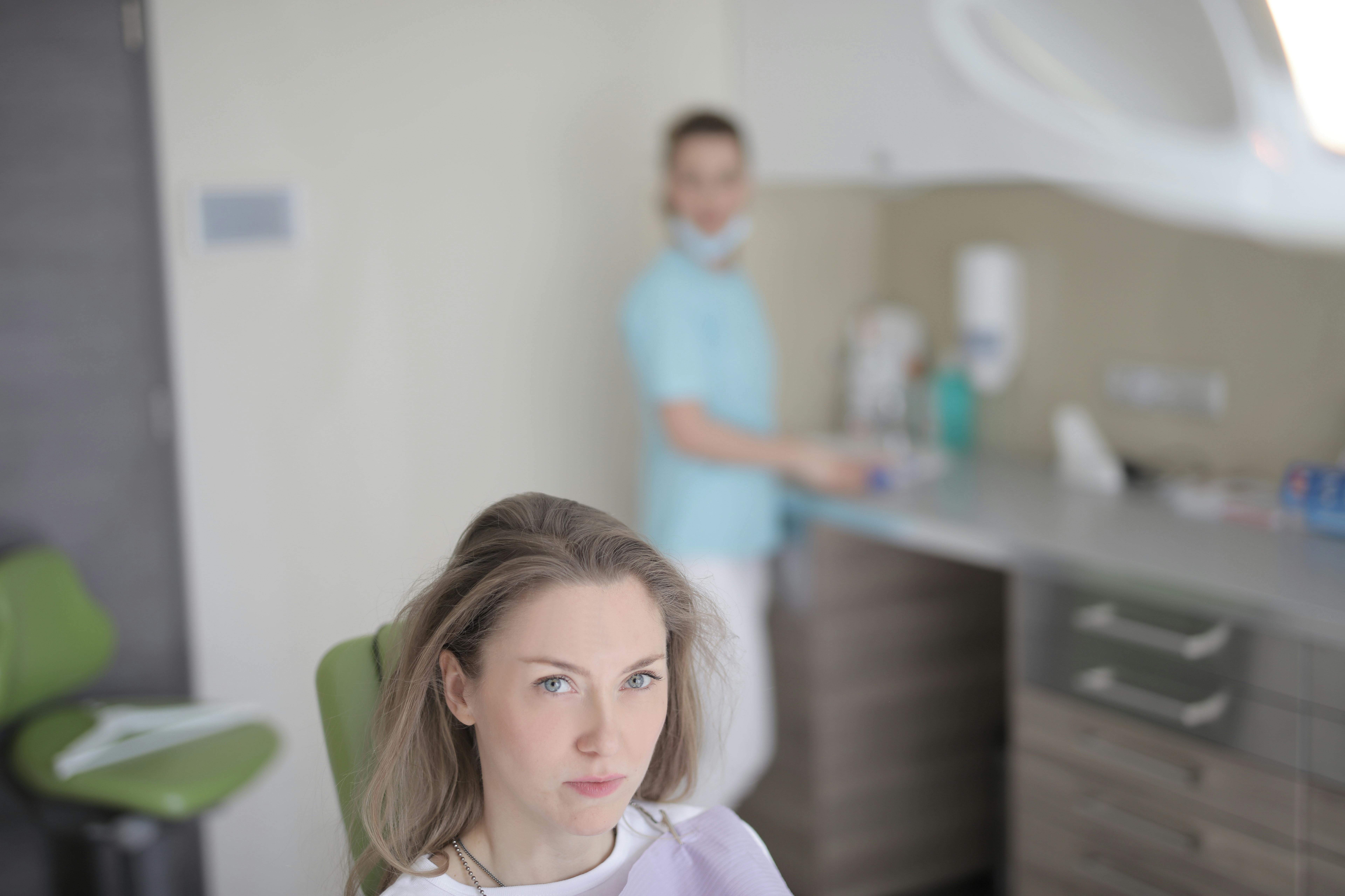 Young female patient preparing for treatment in modern dental clinic ...