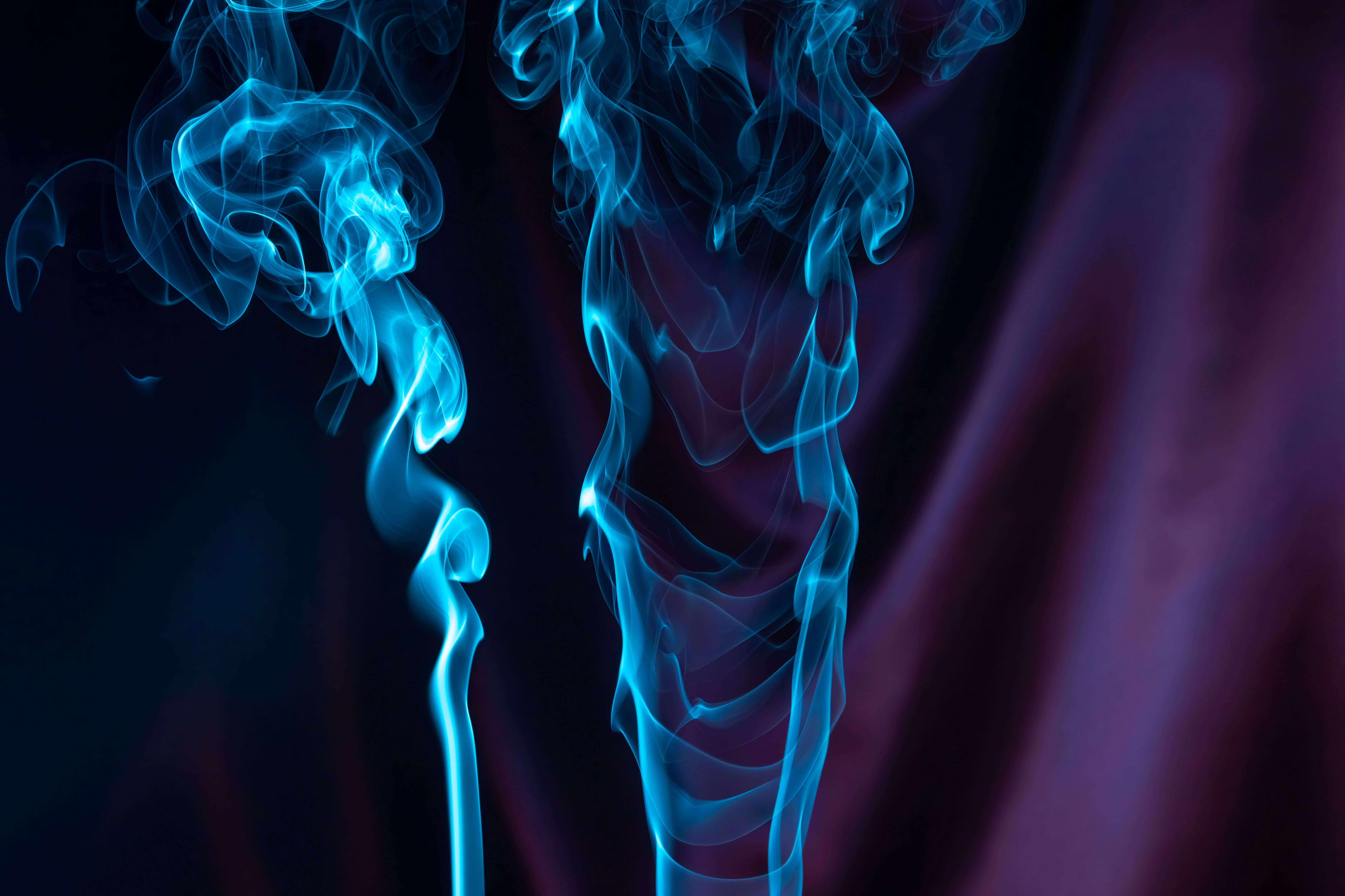 Fotomural Humo azul místico que se arremolina sobre un fondo púrpura intenso, creando una imagen abstracta y relajante.