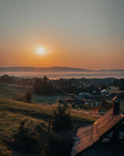 Free Serene sunrise over rolling fields and distant mountains in rural Poland, capturing tranquility and nature's beauty. Stock Photo