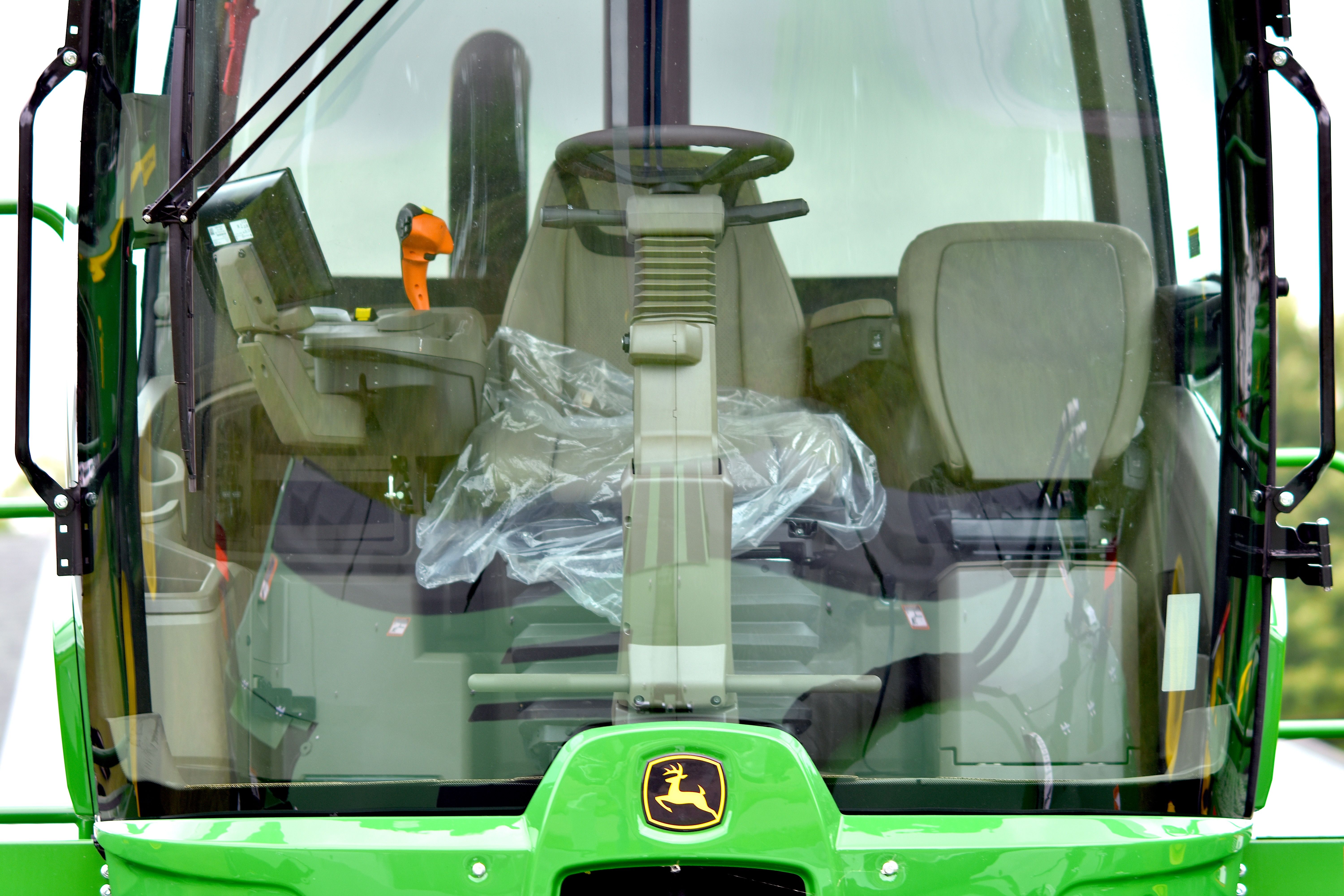 Interior view of a modern tractor cab with advanced equipment and controls, featuring detailed dashboard and seats.