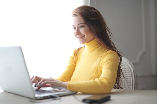 Free Woman in Yellow Turtleneck Sweater Using Laptop Stock Photo