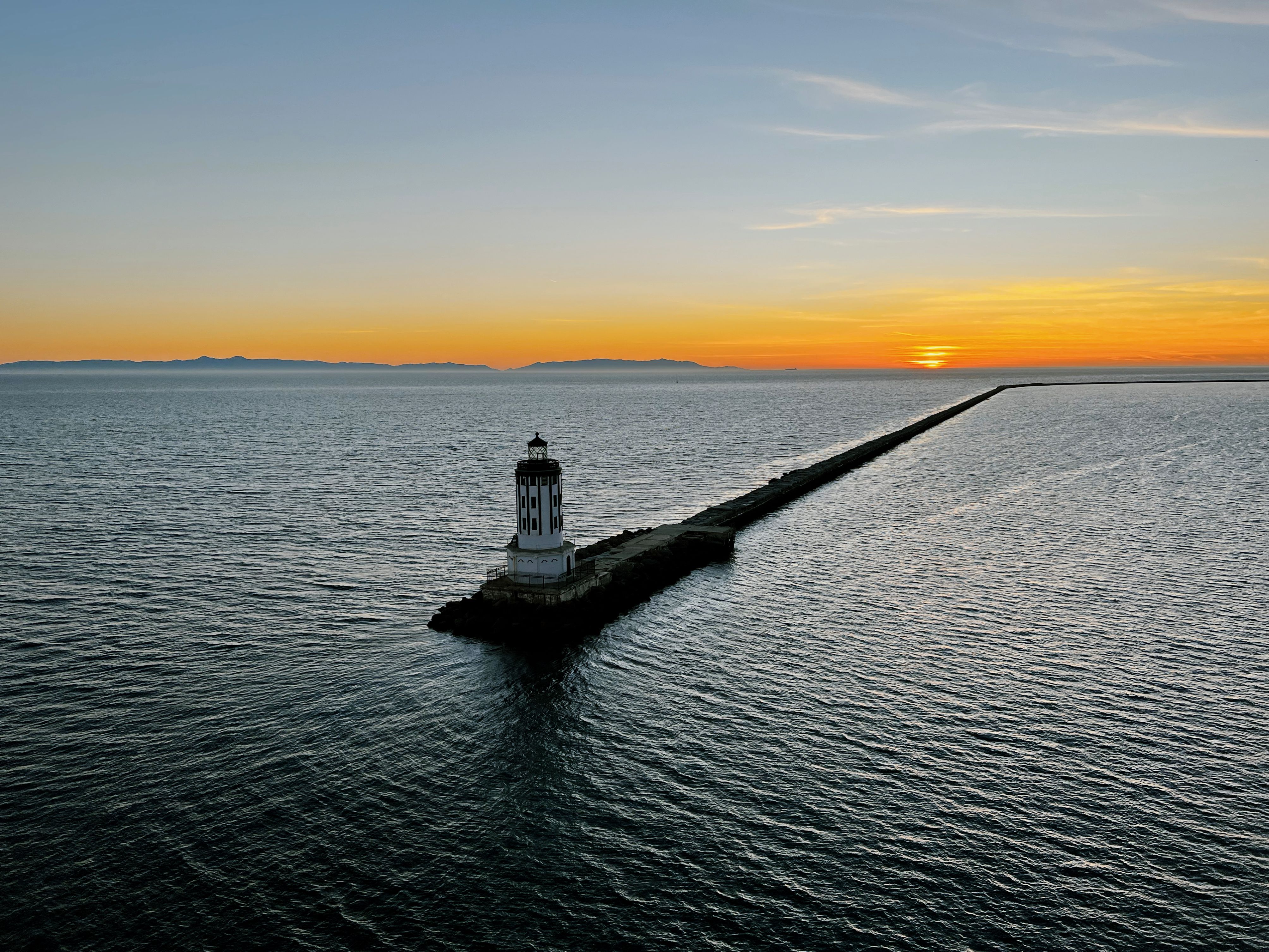 Aerial sunset view of Point Fermin Lighthouse at the Pacific Ocean, creating a serene seascape.