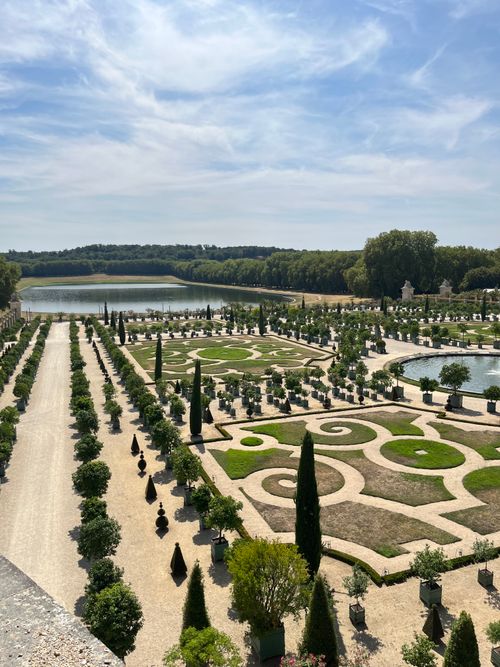 Free Overhead view of the iconic gardens of Versailles on a sunny day, showcasing ornate designs. Stock Photo