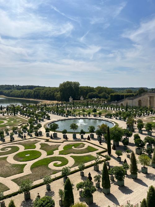 Free Ornate gardens of the Palace of Versailles with geometric designs and lush greenery. Stock Photo