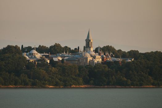 A stunning view of Istanbul's Topkapi Palace surrounded by lush greenery during golden hour.