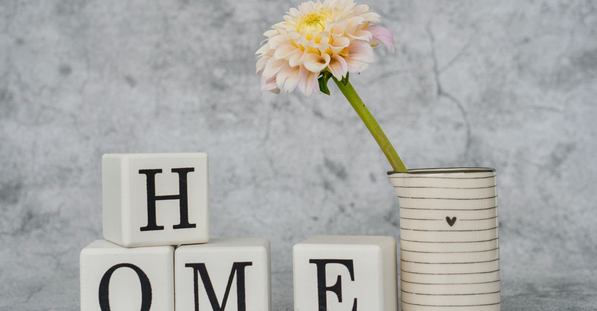 Charming home decor featuring letter blocks spelling 'HOME' with a flower in a striped vase.