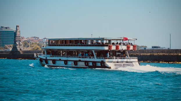 A ferry navigates the Bosphorus under the clear blue sky in Istanbul, Turkey.