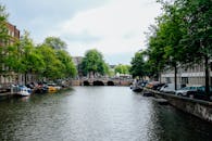 阿姆斯特丹宁静的运河、郁郁葱葱的树木、船只和历史建筑构成了一幅美丽的景观