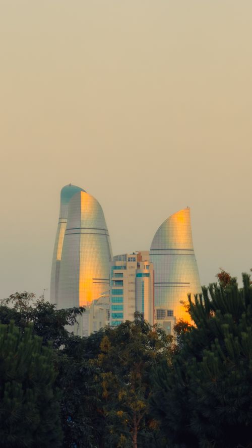 Free Scenic sunset view of the iconic Flame Towers in Baku, Azerbaijan surrounded by greenery. Stock Photo