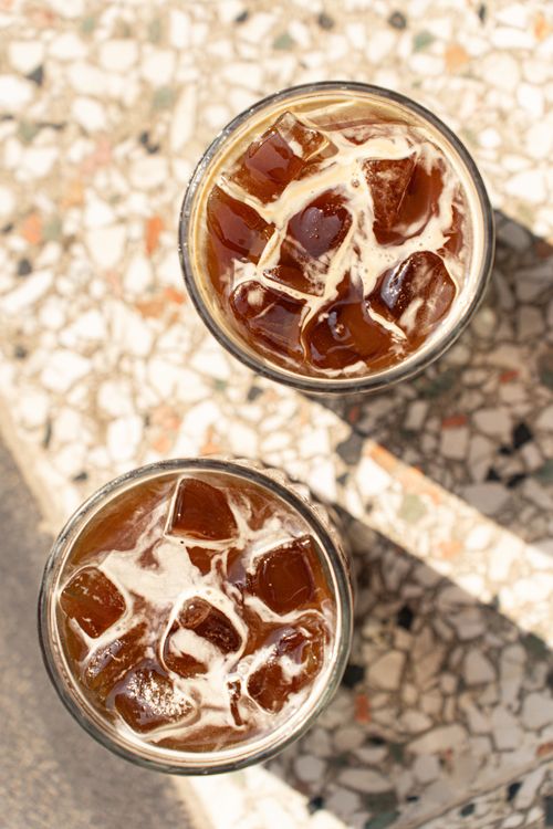 Free Top view of two glasses of iced coffee with milk on a terrazzo table, perfect for a summer refreshment. Stock Photo
