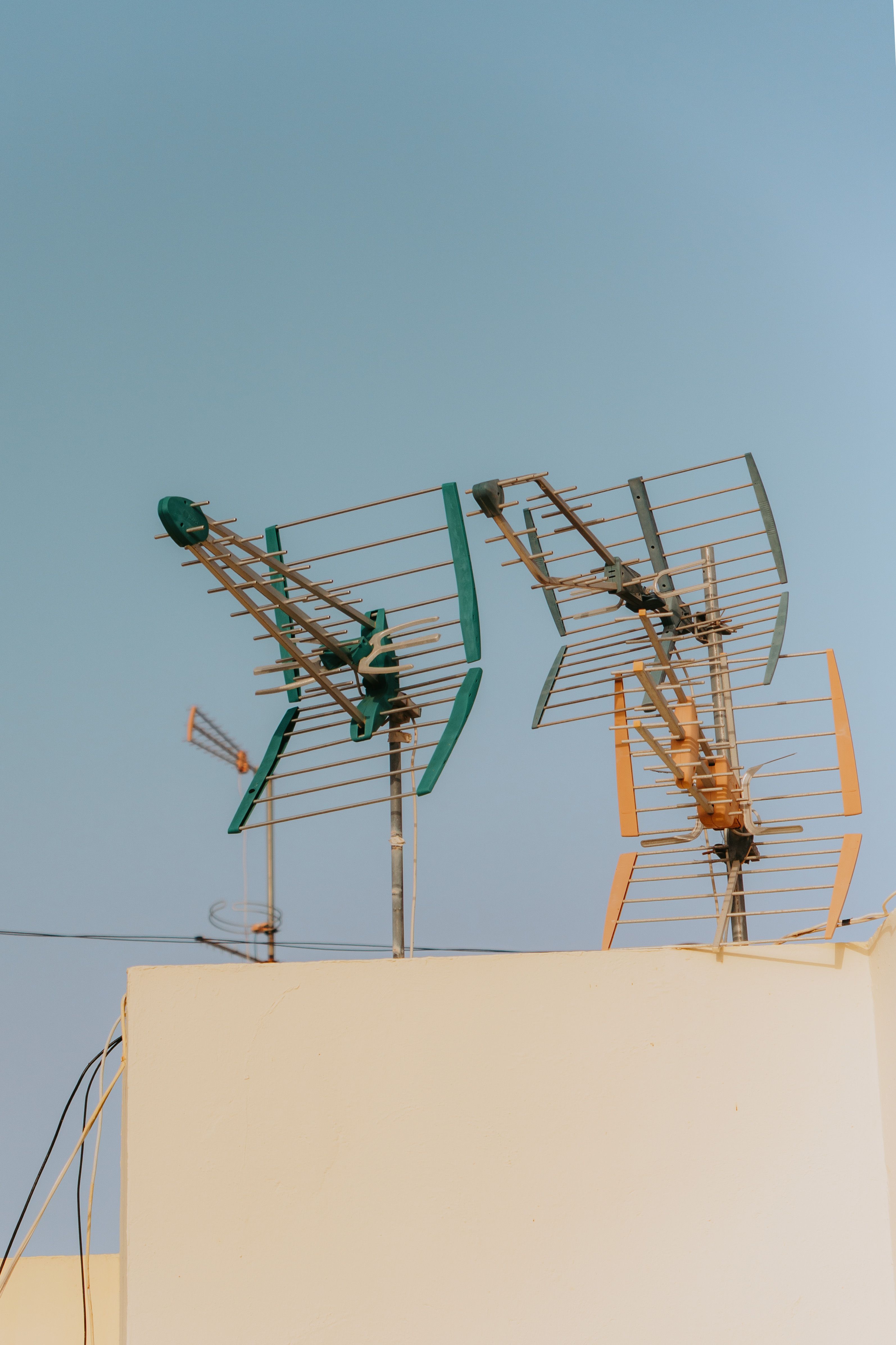 Deux antennes râteau sur un toit, sous un ciel bleu