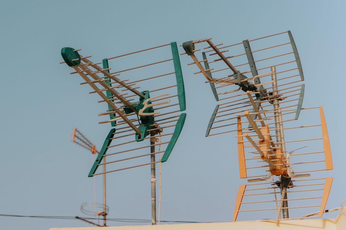 Deux antennes râteau sur un toit, sous un ciel bleu