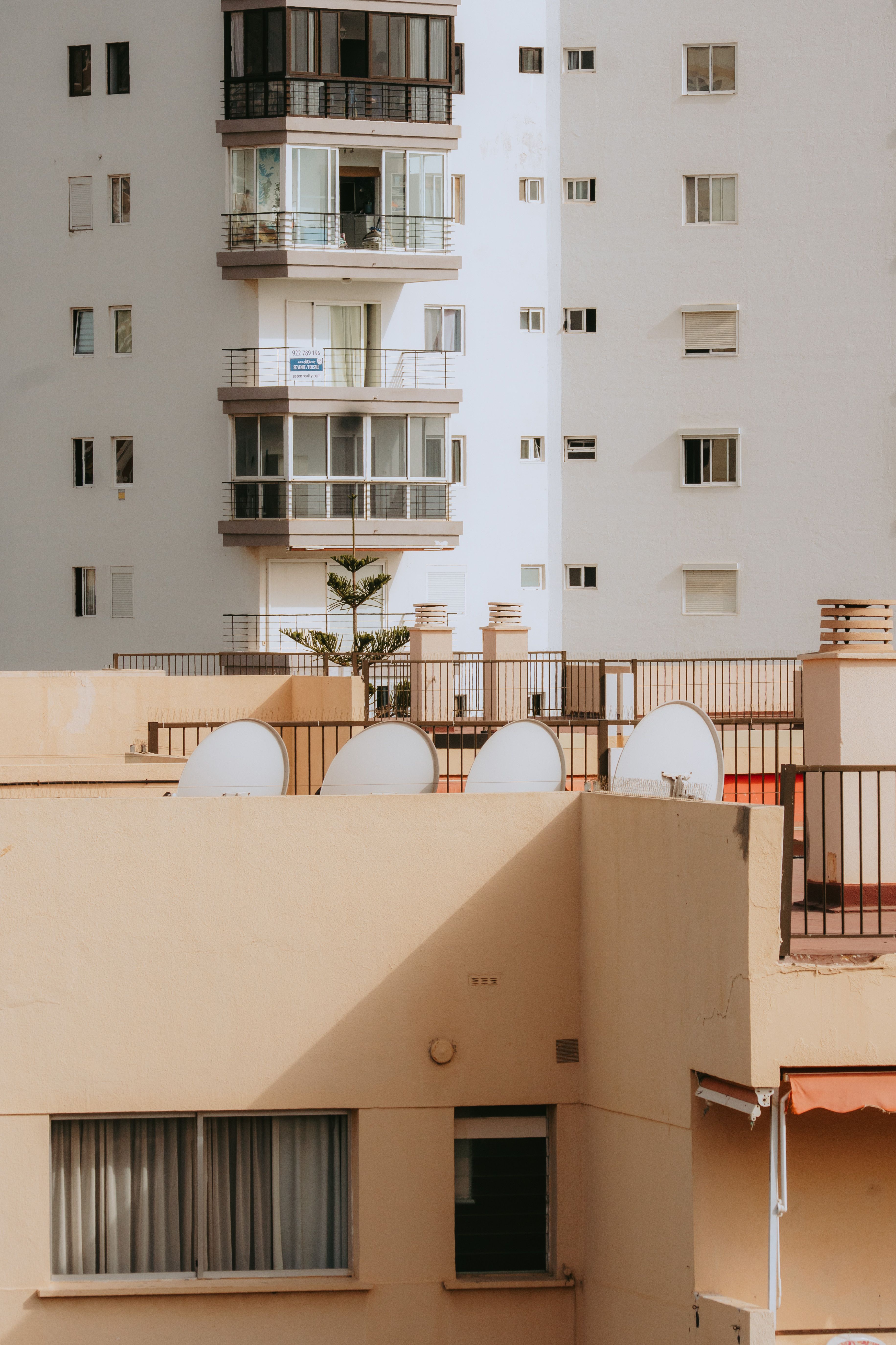 Explore the geometric facades and warm light on a sunny day in Los Cristianos, Spain.